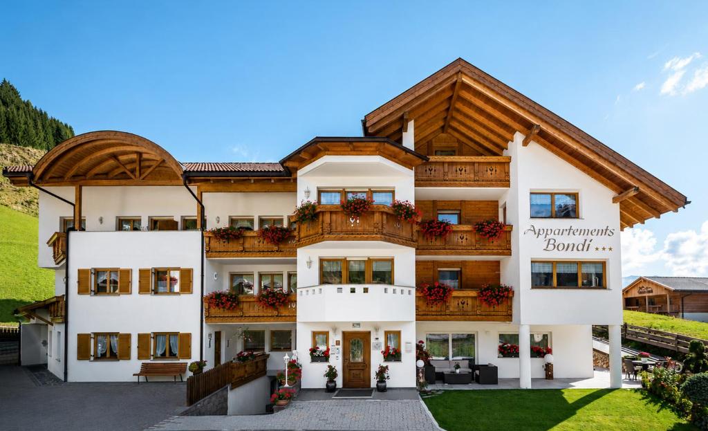 an apartment building with a wooden roof at Residence Bondì in Colfosco