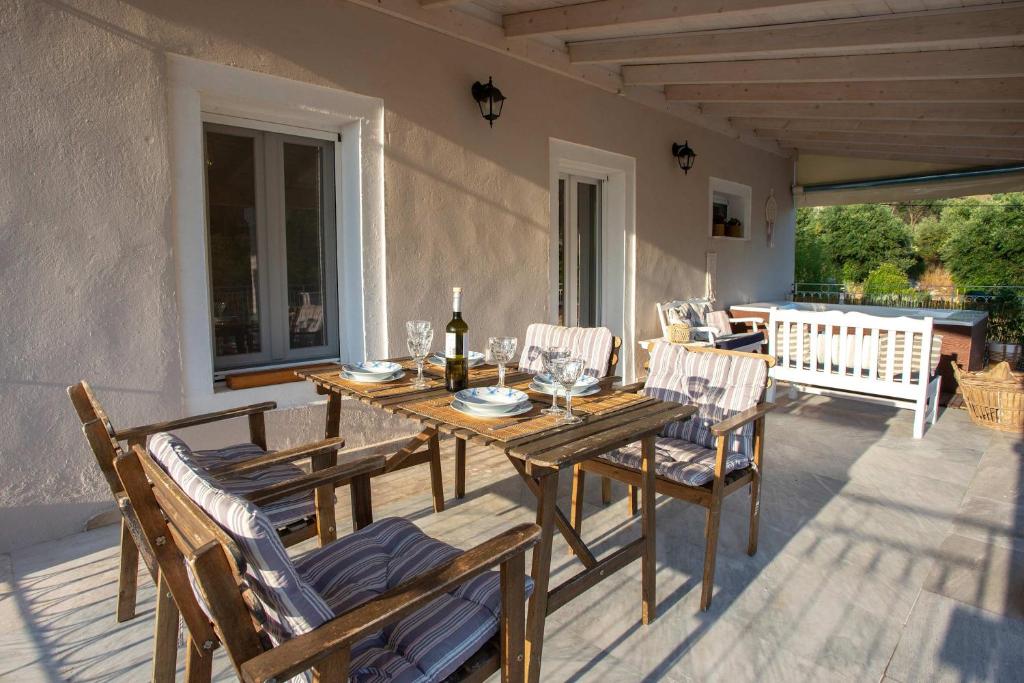 a wooden table and chairs on a patio at Casa Sulla Montagna North Corfu in Loútsai