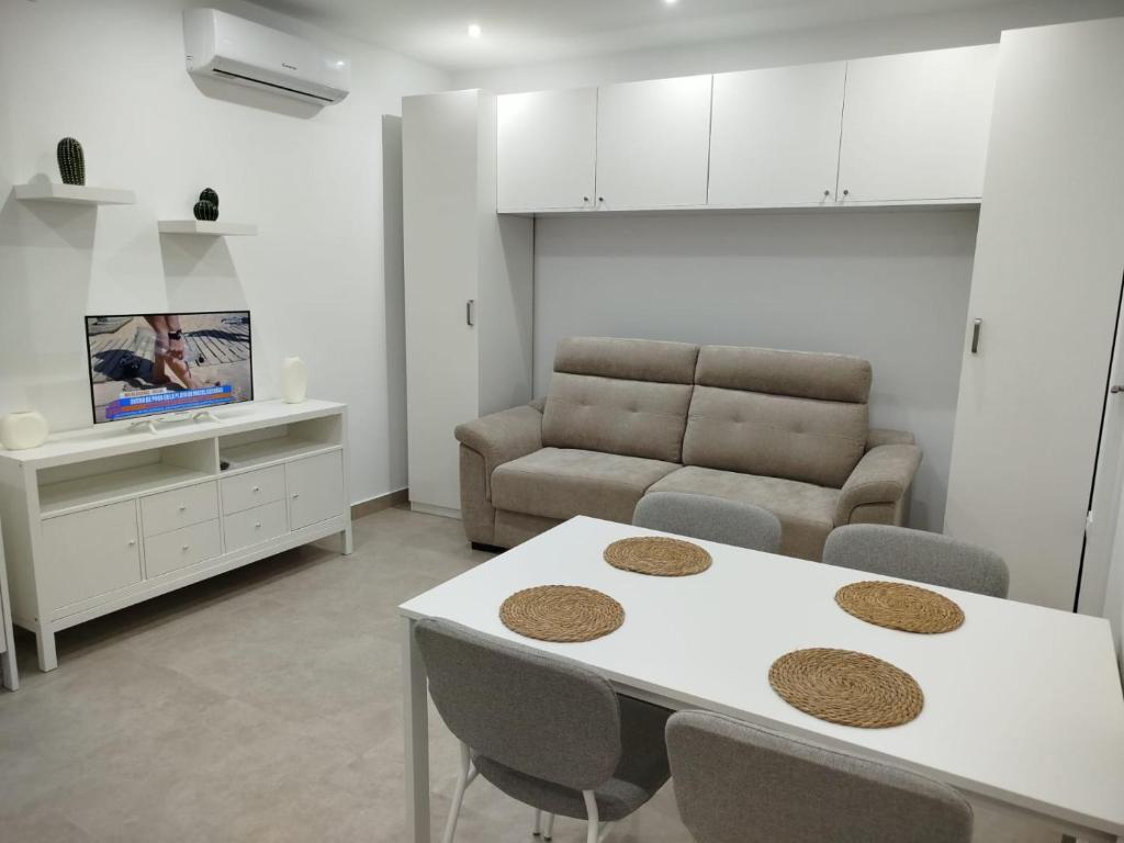 a living room with a table and a couch at Aires de Chipiona Apartamento B in Chipiona