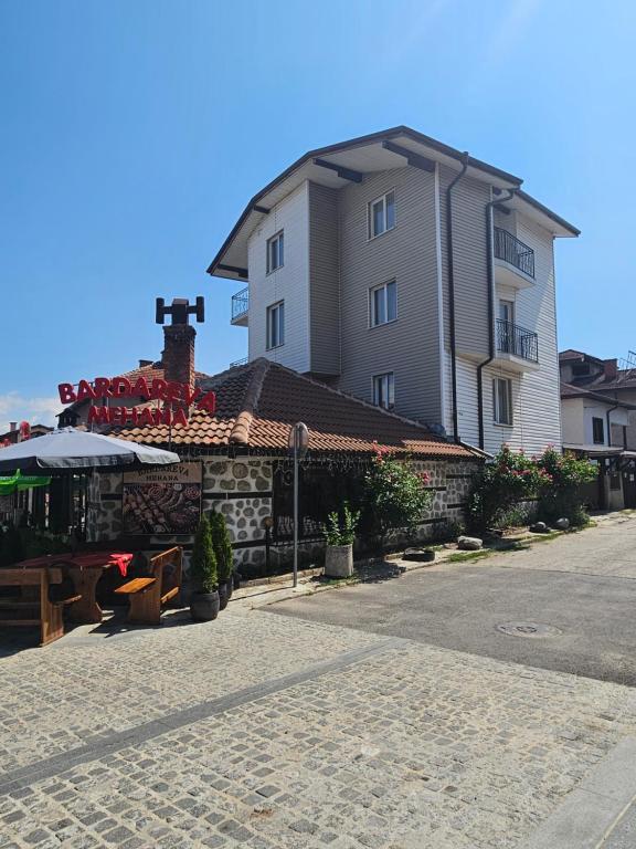 a large building with a table in front of it at Cтаи за гости Бърдареви in Bansko