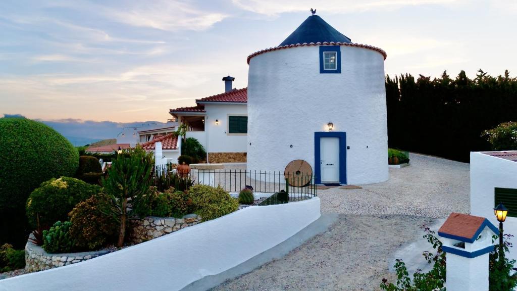 a white house with a blue roof at Moinhos Da Guimaroa in Cadafais