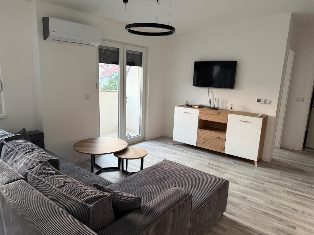 a living room with a couch and a table at Stan centar Gračanica in Gračanica