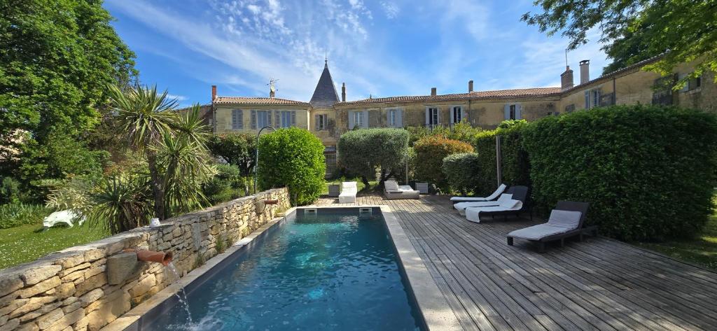 a backyard with a swimming pool and a house at Le Clos Réaud in Blaye