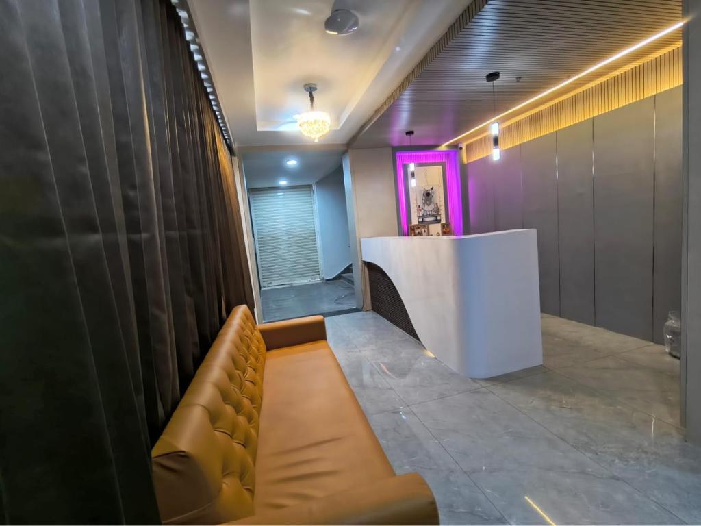 a waiting room with a counter and a couch at Hotel Satyam in Vadodara