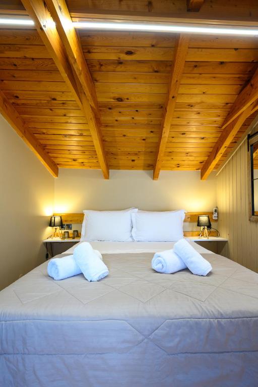 a bedroom with a large bed with wooden ceilings at Swan Paradise Nafplio in Nafplio