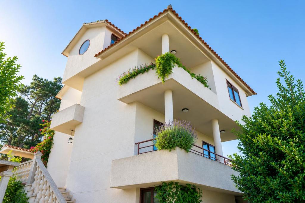 a white building with plants on it at Villa Aldán Areacova in Aldán
