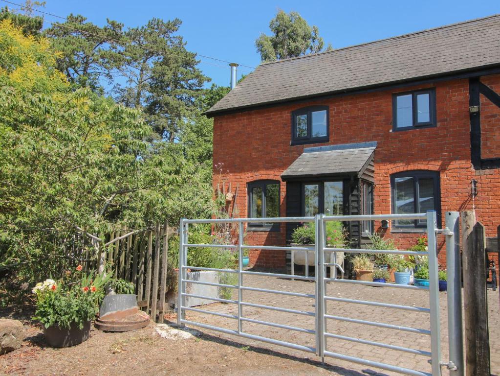 a brick house with a gate in front of it at Chess Cottage in Hereford