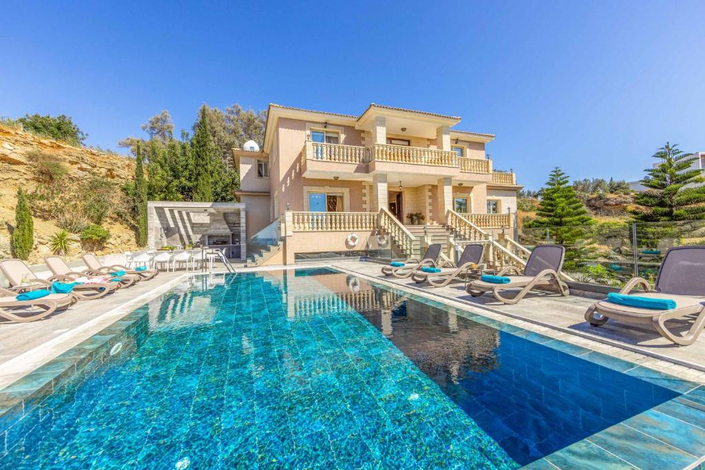 a house with a swimming pool in front of a house at Villa Vasilissa in Argaka