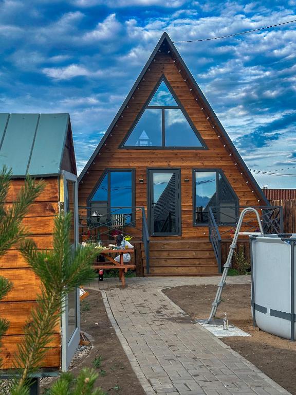 a log cabin with a large window on the front of it at Zhaltyr resort in Astana