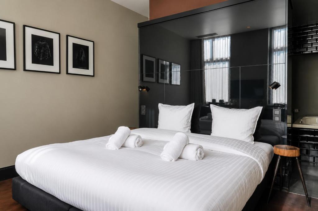 a bedroom with a large bed with white pillows at Les Nuits in Antwerp