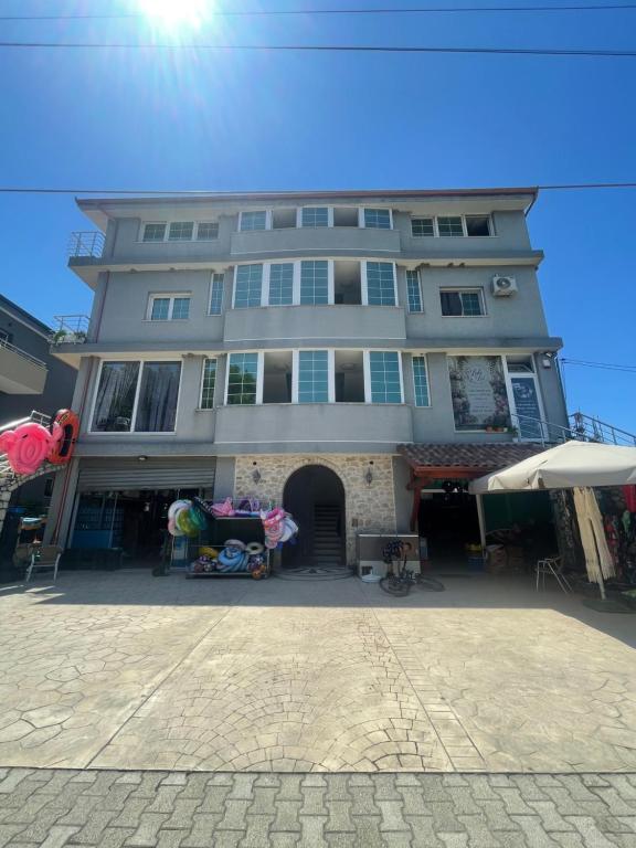 a large gray building with an umbrella in front of it at Hotel Luis in Durrës