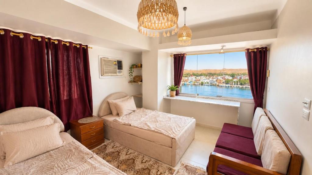 a bedroom with a bed and a window at Anuket House in Naj‘ al Maḩaţţah