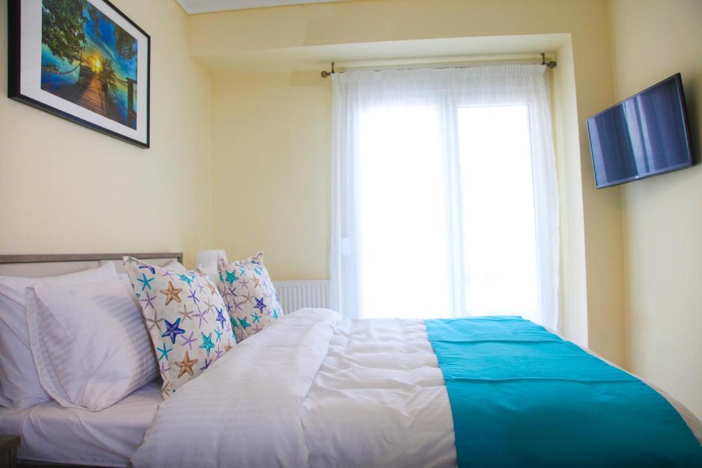 a bedroom with a bed with a large window at Apartments Holiday in Perea