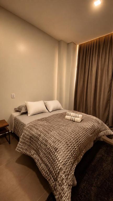 a bedroom with a bed with two pillows on it at Sely Suítes in Ametista do Sul