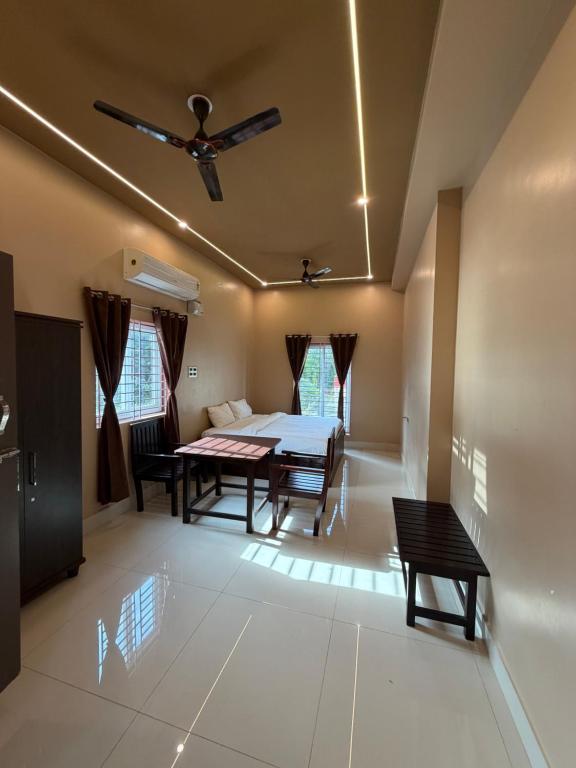 a living room with a table and a ceiling fan at JRR room stay in Thiruvaiyāru