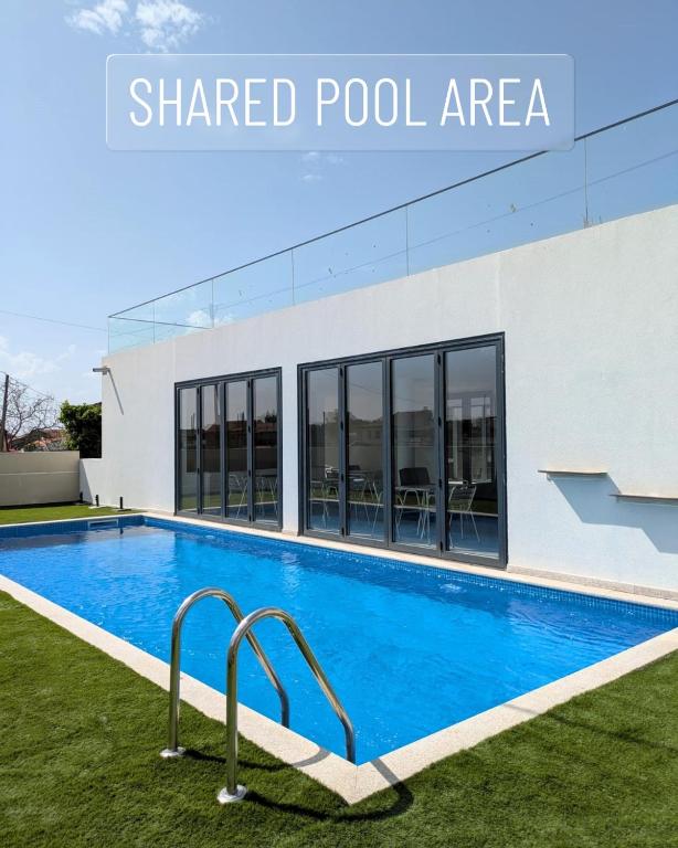 a swimming pool in front of a building with the words shared pool area at Casa do Margalho in Miranda do Douro