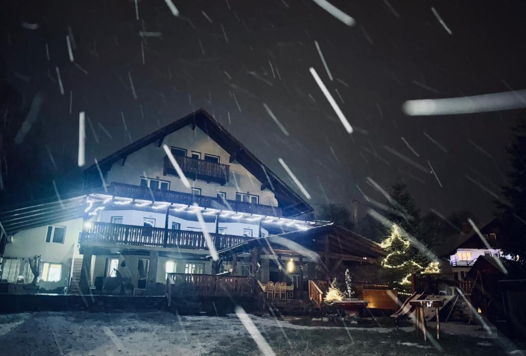 a house in the snow at night at Villa Bran Legend in Bran