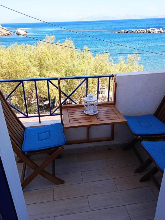 a balcony with a table and chairs and the ocean at Alkistis Apartments, 1st floor in Agios Kirykos