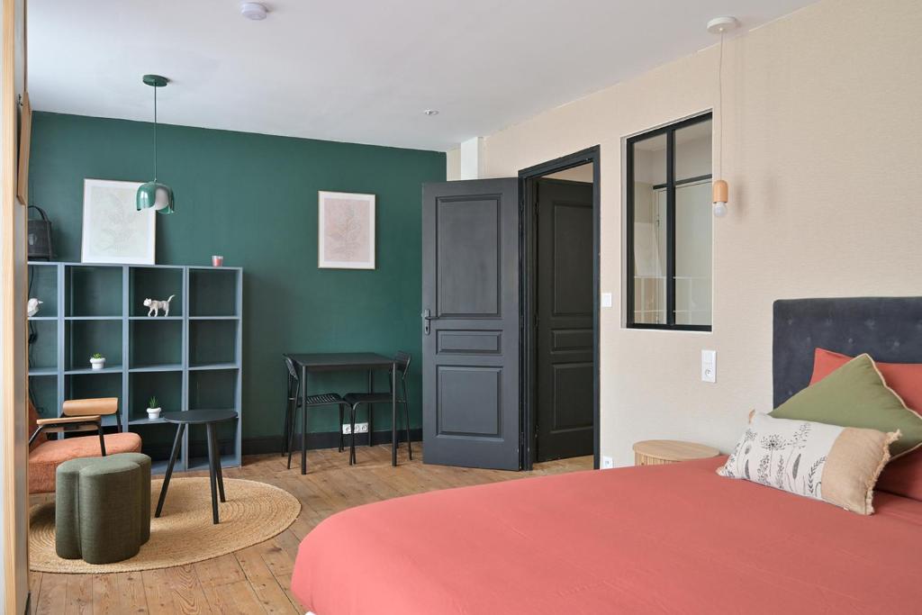a bedroom with a red bed and a green wall at Brunhilde in Montivilliers