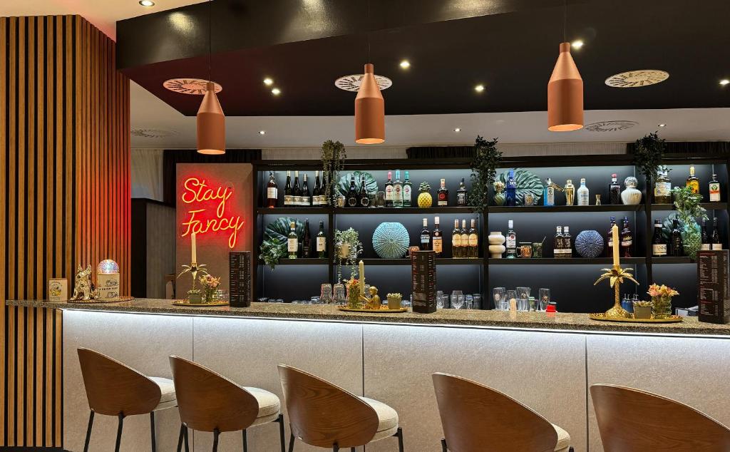 a bar in a restaurant with chairs in front of it at DORMERO Hotel Fürth in Fürth