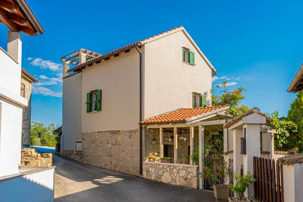 a large white house with a stone wall at Holiday House Rea with BBQ and two terrace in Sveti Donat