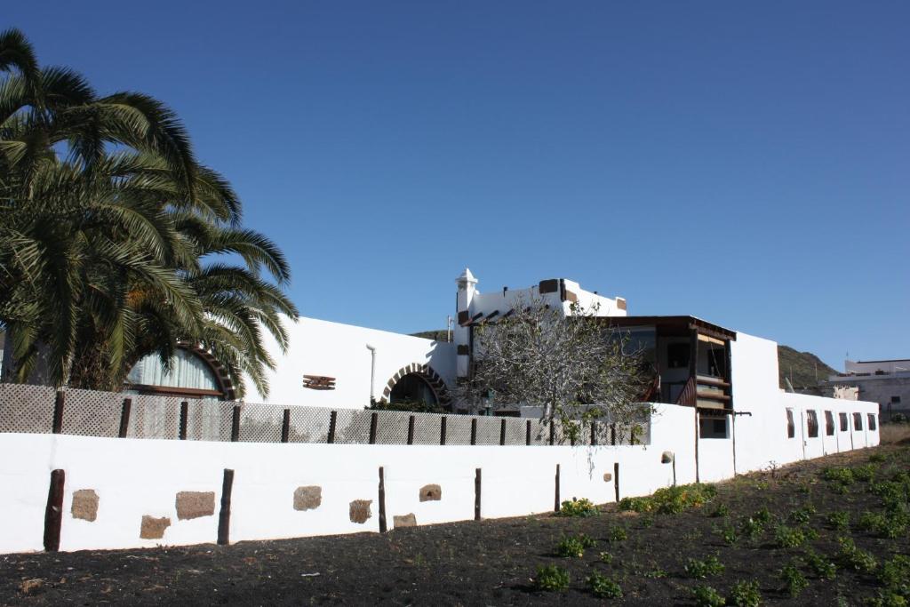 una valla blanca con un edificio en el fondo en Casa Rural "La Molina", en Máguez
