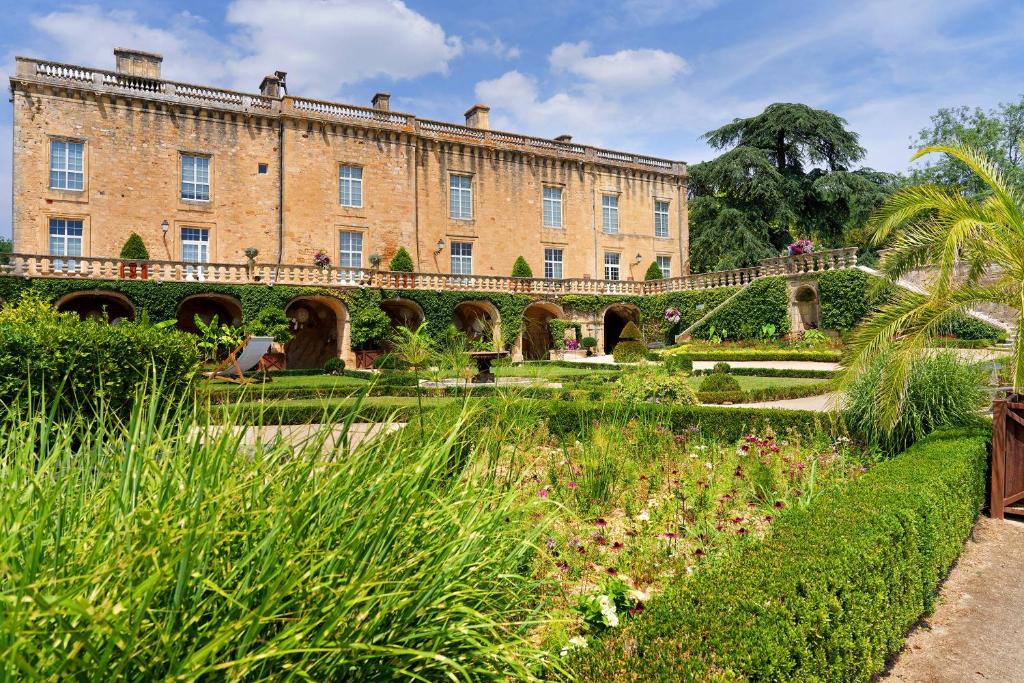 a large brick building with a garden in the foreground at Studio Montayral in Montayral