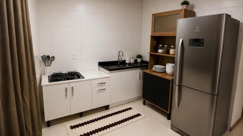 a small kitchen with a stainless steel refrigerator at Apartamento Completo Próximo a BR in Biguaçu