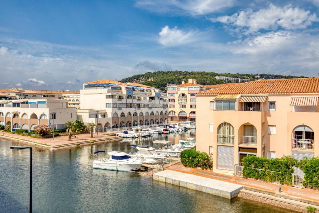 a group of buildings and boats in a harbor at L'escale Marine Air-conditioning in Sète