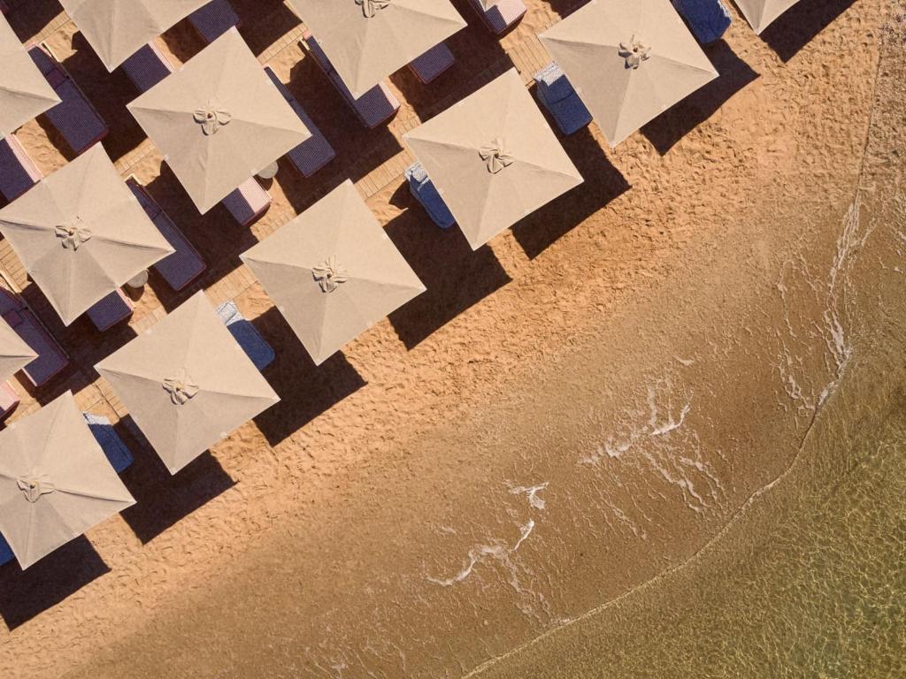 an overhead view of a beach with umbrellas at Golden Milos Beach Ηouse by Domotel in Provatas