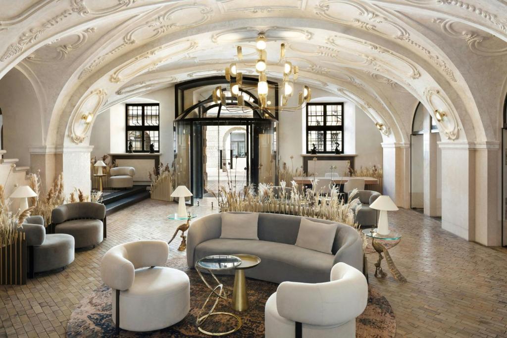a lobby with a couch and tables and chairs at H15 Palace, a Luxury Collection Hotel, Krakow in Krakow