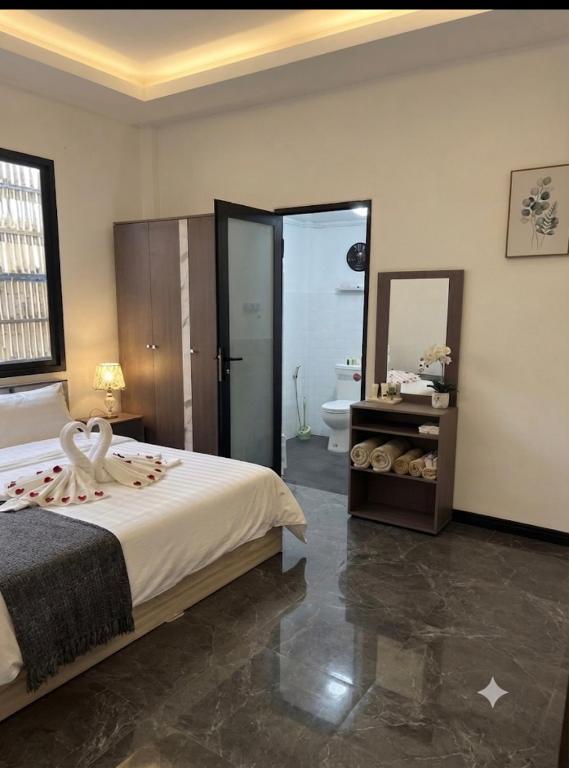 a bedroom with a bed and a bathroom with a mirror at SET Guesthouse 3 in Kata Beach