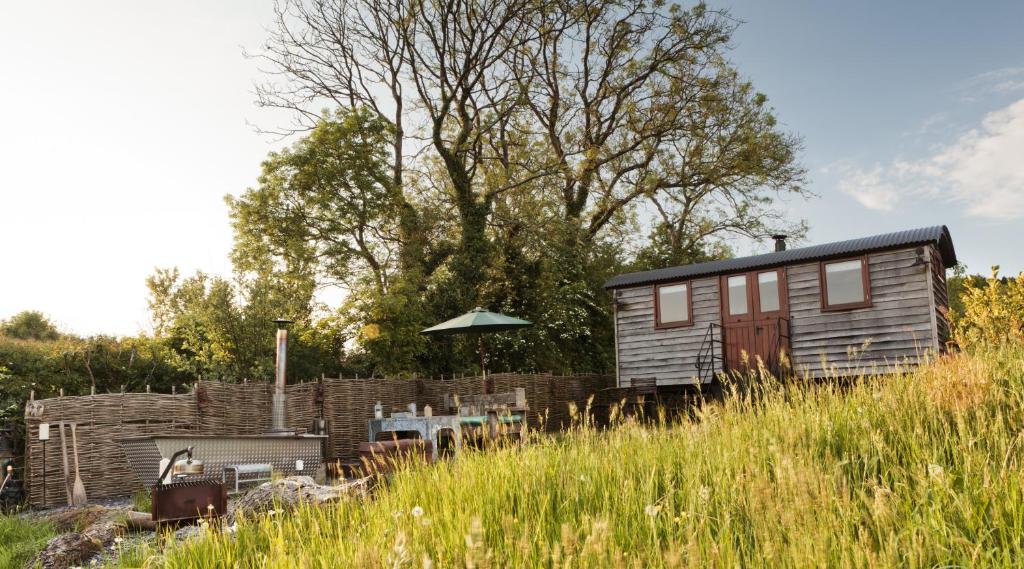 a tiny house sitting on top of a field at Lens Hut in Masbury Station