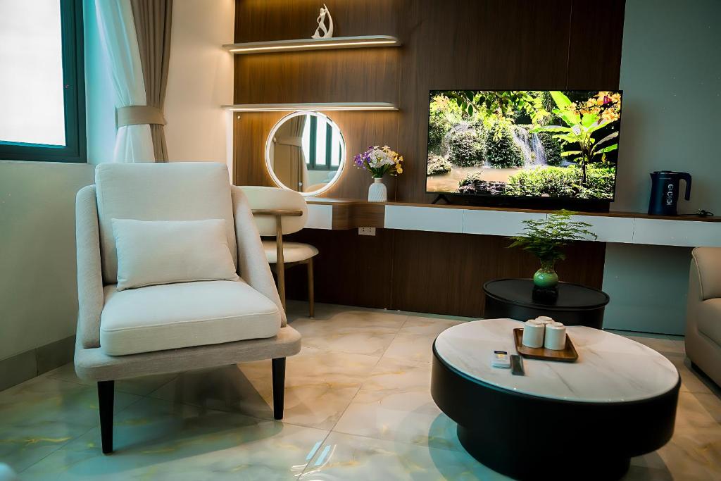 a living room with a chair and a tv at T&T Luxury Hotel Đồi Ngô in Bắc Ninh