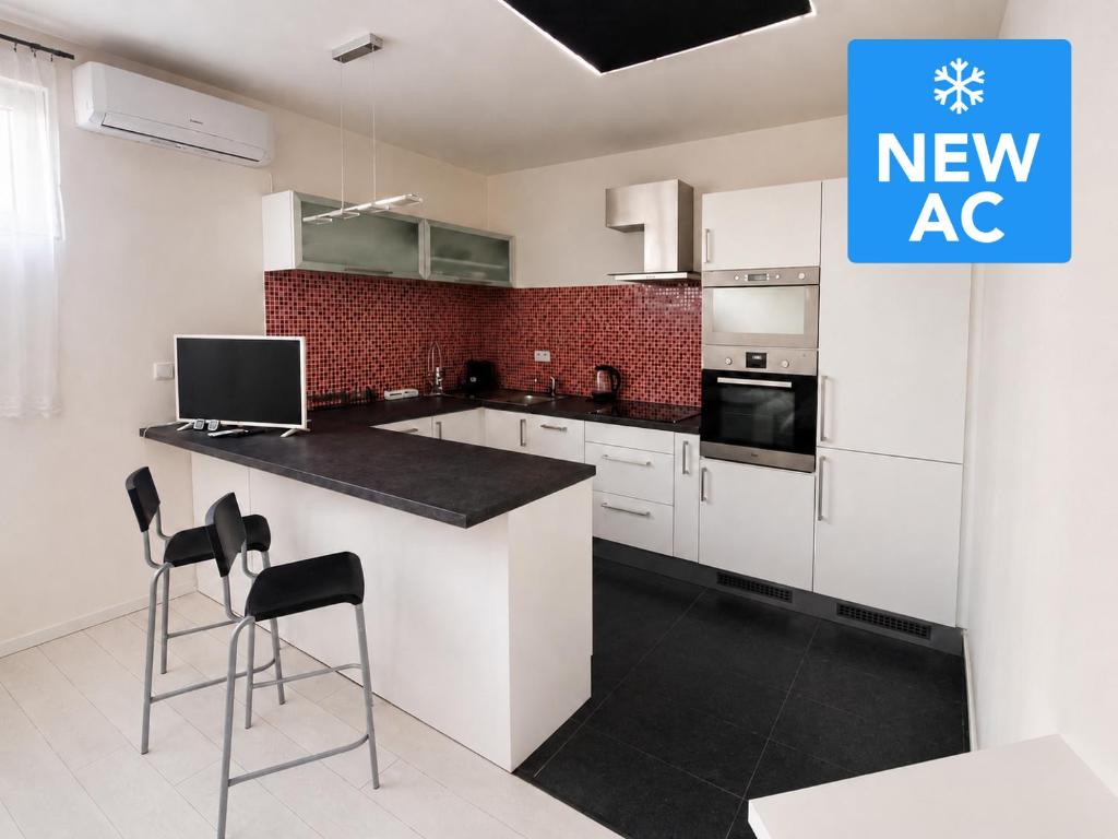 a kitchen with a new ac sign on the wall at RUMAKO apartments in Prague