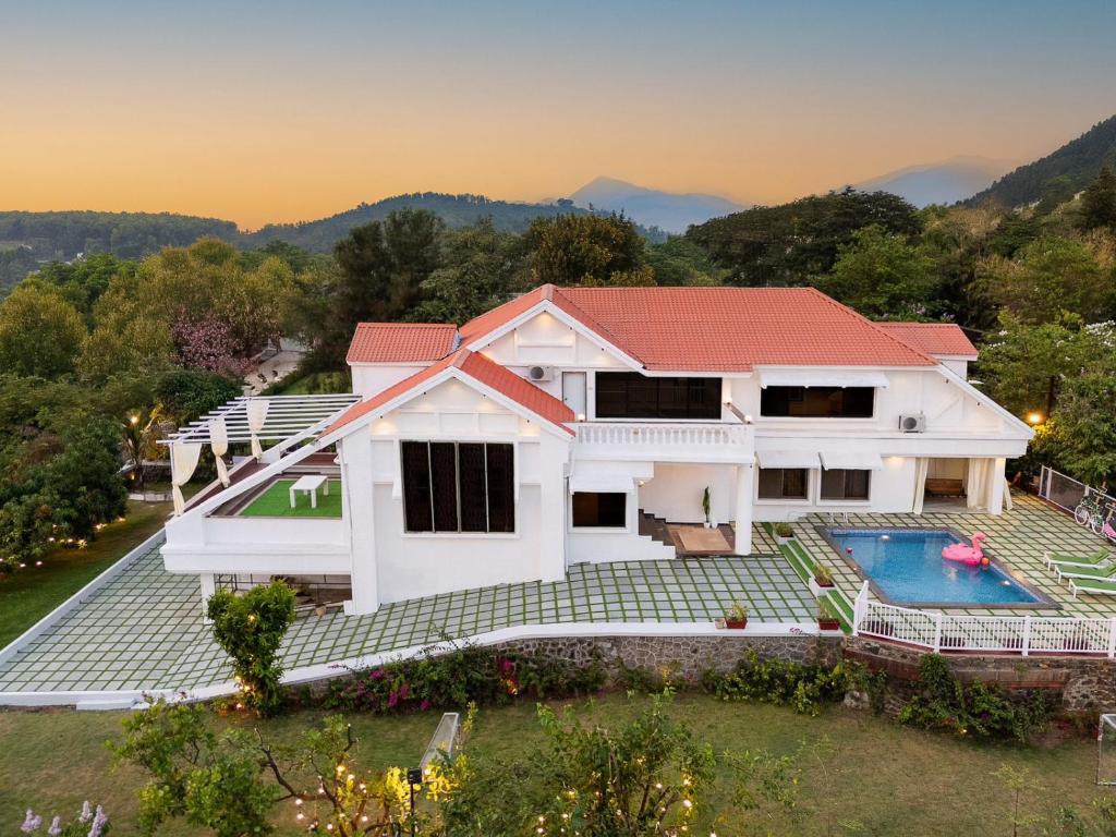 an aerial view of a house with a swimming pool at EKOSTAY Luxe - Noah Villa with Peddle Court & Sunset View in Lonavala