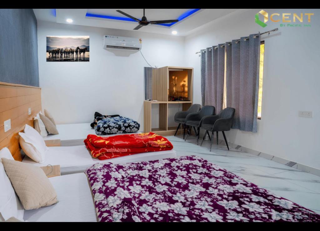 a bedroom with a bed and chairs in a room at Qcent Bairagarh Resort Rishikesh in Mohan Chatti