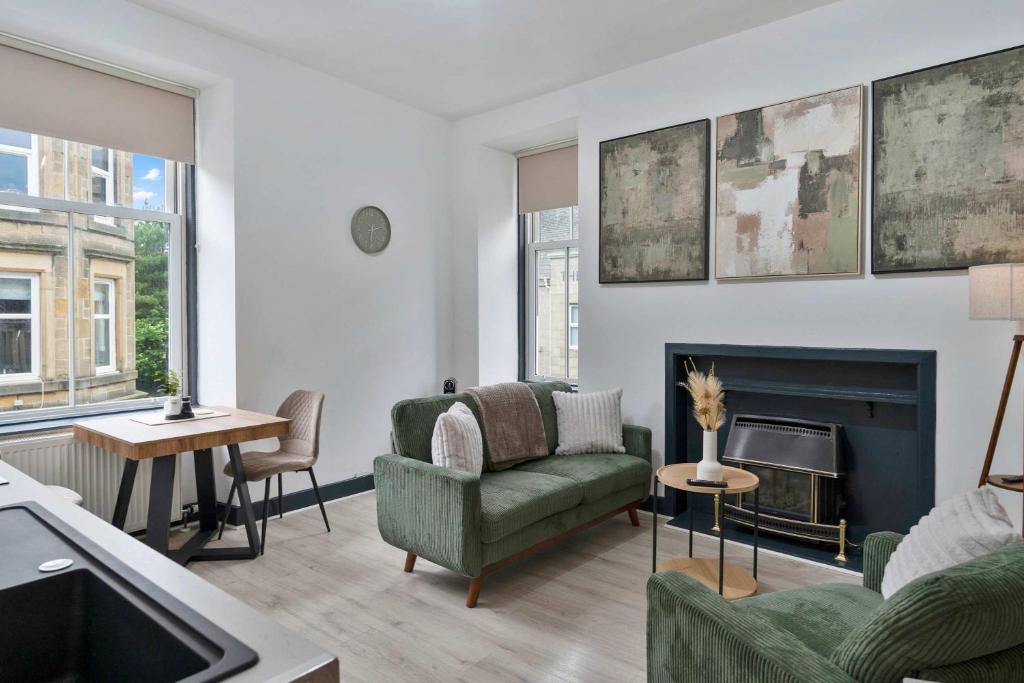 a living room with a green couch and a fireplace at Contractor-Friendly - Hawick - Free Parking - 2BR in Hawick