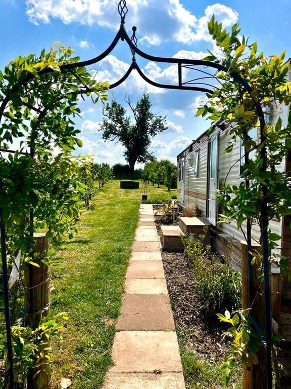 a garden with a row of benches and a building at The Lodge - 3BR, Woodland Forge, Garden Patio, Parking, Sleeps 6 in Over Whitacre