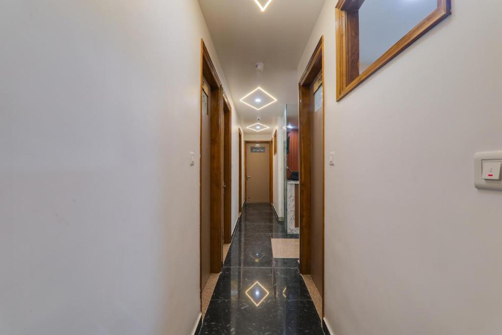 a hallway with a long hall with lights on the ceiling at Hotel O Happy Times Vishveshwar Park in Gomti Nagar