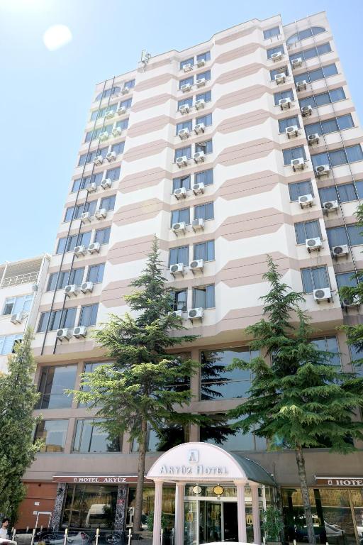 a tall building with trees in front of it at Akyuz Hotel in Ankara
