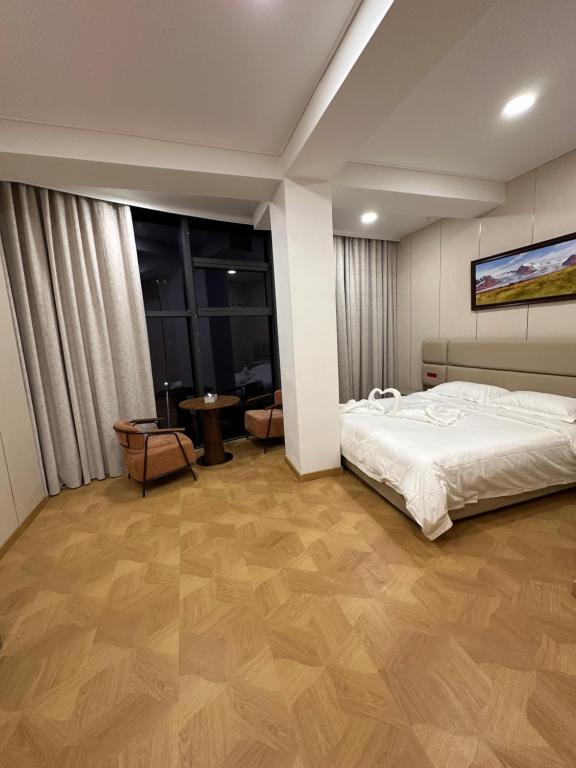 a bedroom with a white bed and wooden floors at Zarya in Ölgiy