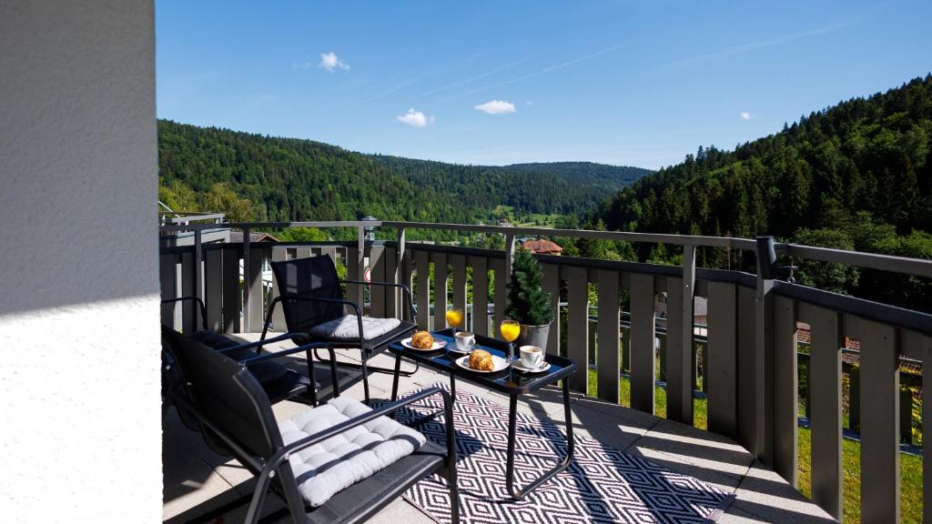 a balcony with a table and chairs and a view at Ferienwohnung Panoramablick - super für deine Familie und die besten Aussicht in ganz Todtmoos in Todtmoos