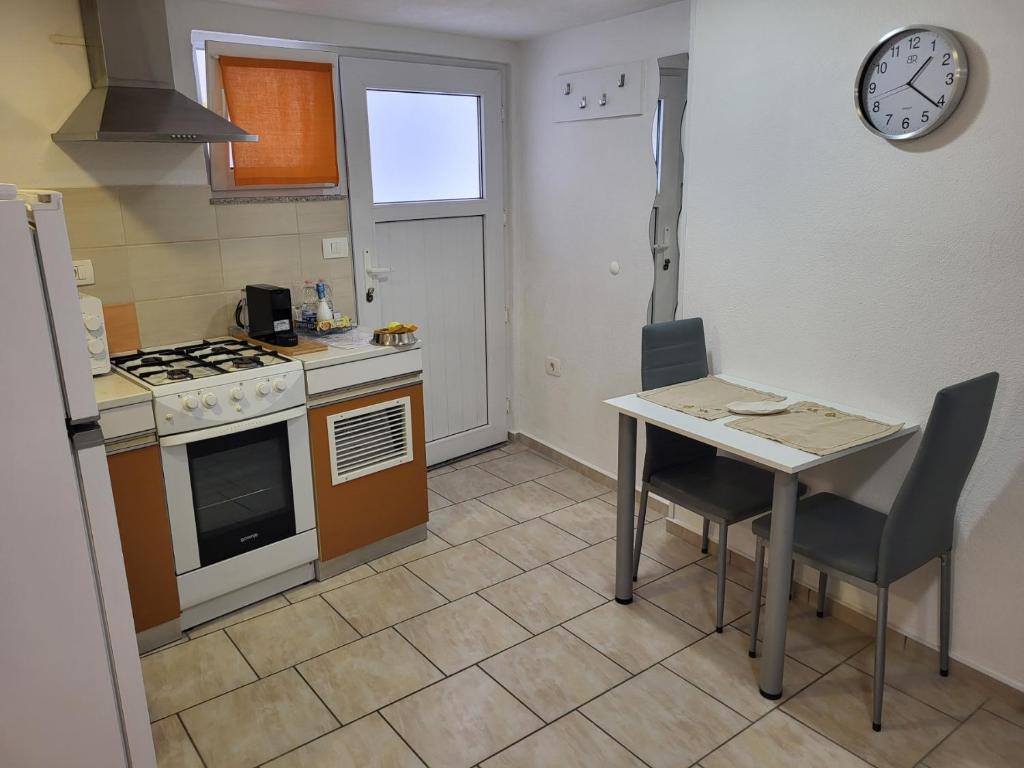 a small kitchen with a table and a stove at Apartma Oliva in Koper