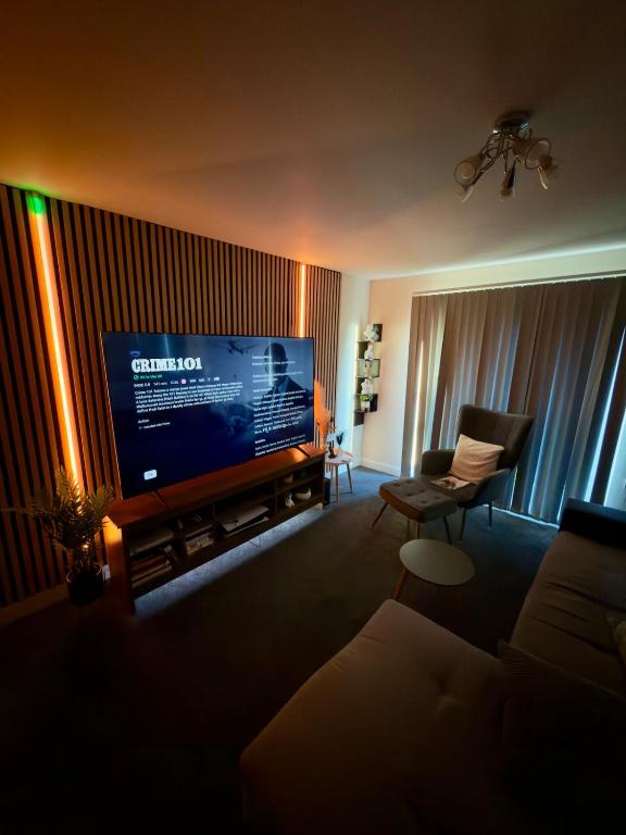 a living room with a large flat screen tv at Blackrod Homestay in Blackrod