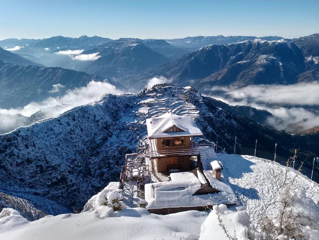 a building on the top of a snow covered mountain at Kali Tibba Resort Chail in Chail