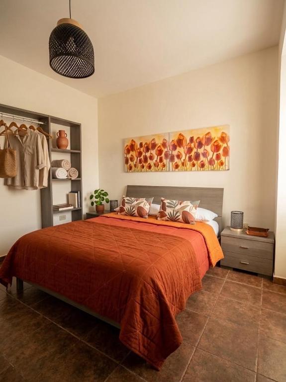 a bedroom with a bed with a orange bedspread at Dimora Filangeri in Santa Flavia