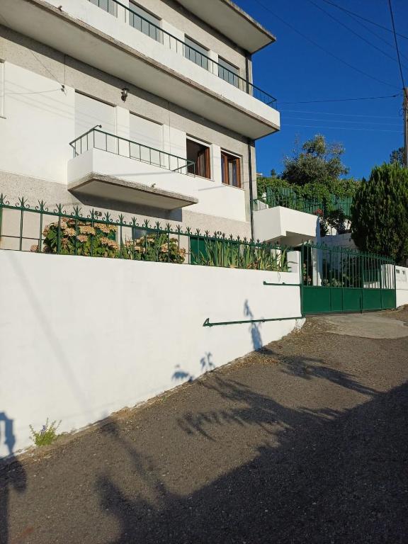 a white building with a white wall and a fence at Serra Viva in Cortes do Meio