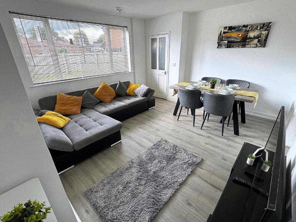 a living room with a couch and a table at Spacious 3 Bed House in Northampton - Sleeps 6 - Driveway Parking - Fast WiFi in Kingsthorpe