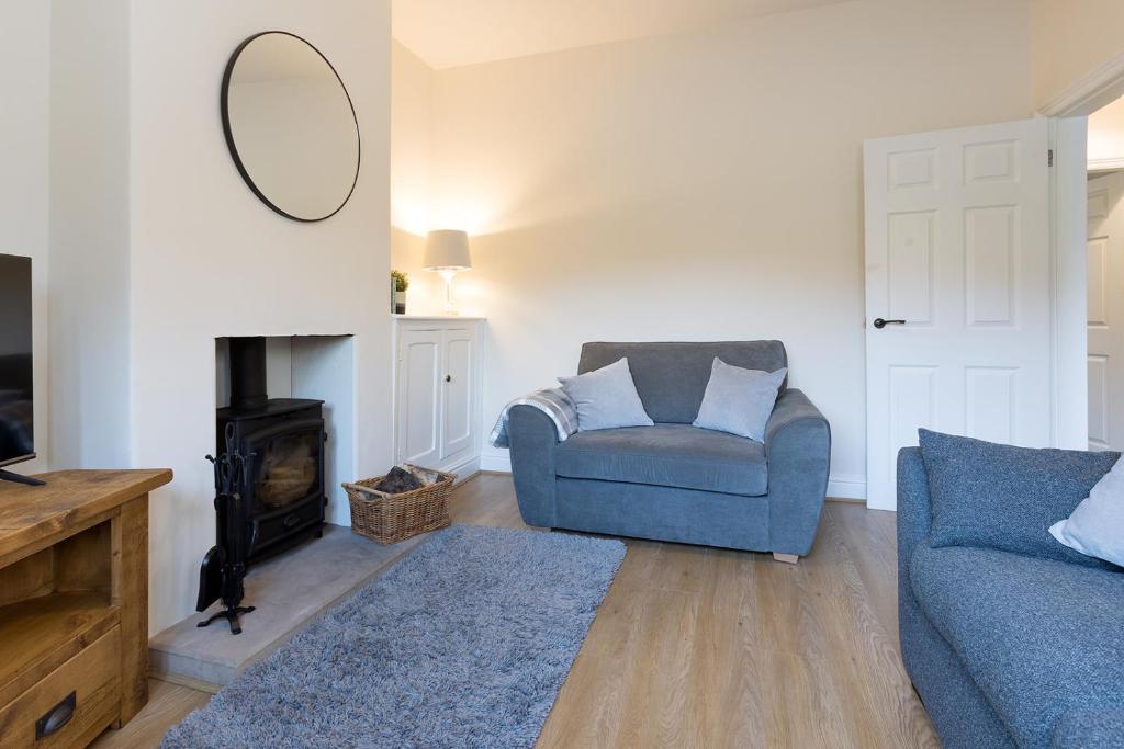 a living room with a blue couch and a mirror at Vera's cottage in Edale